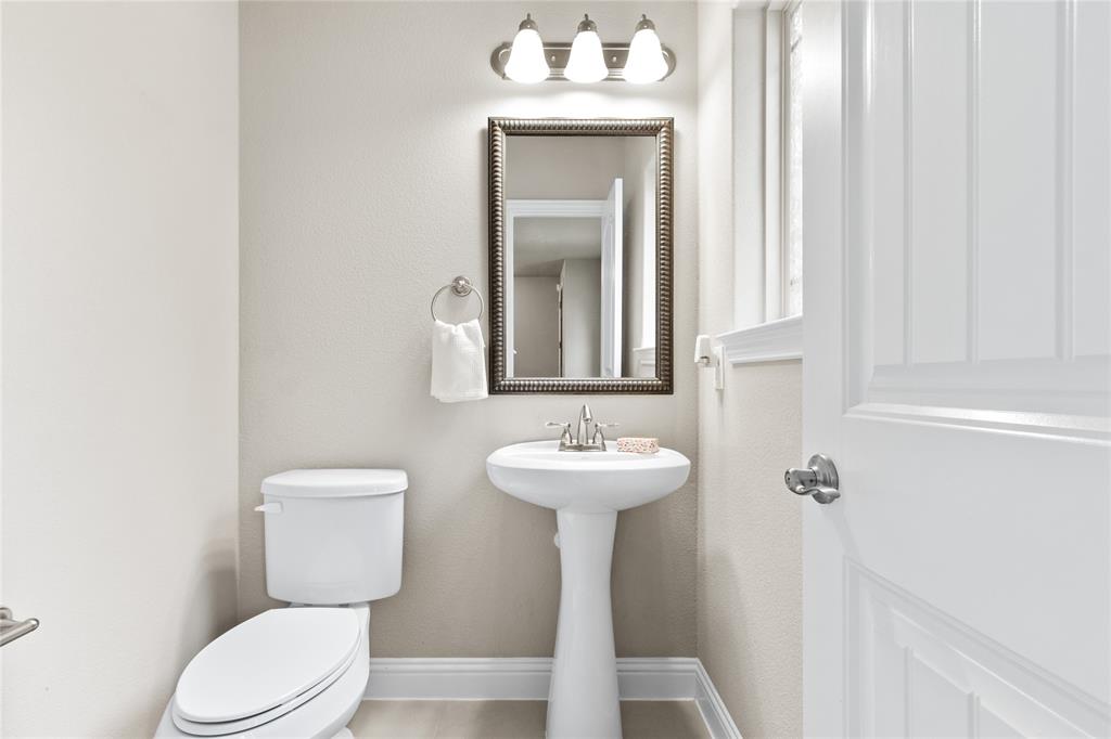 313 Tottenham Court McKinney, TX 75072 - Photo 19 of 31 a bathroom with a toilet sink and mirror