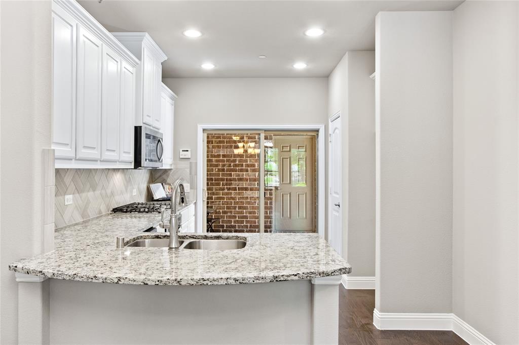 313 Tottenham Court McKinney, TX 75072 - Photo 7 of 31 a kitchen with granite countertop a sink and a stove top oven