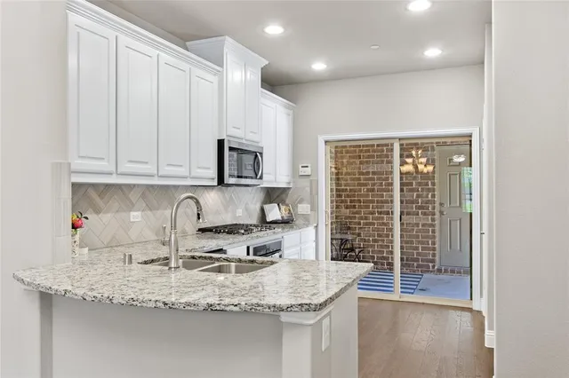 a kitchen with granite countertop a sink a stove and cabinets