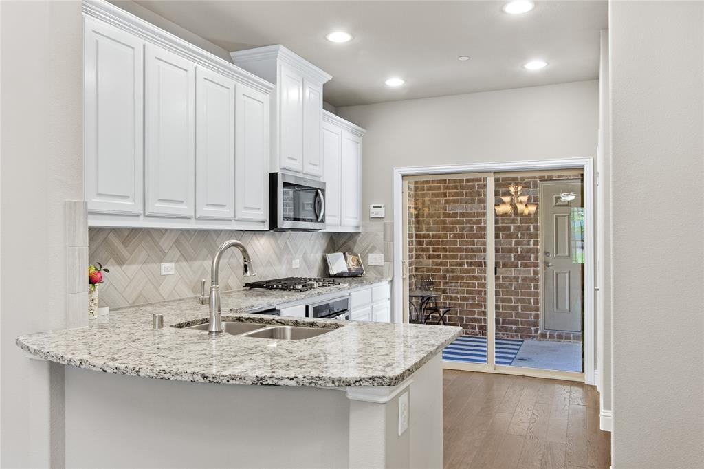 313 Tottenham Court McKinney, TX 75072 - Photo 8 of 31 a kitchen with granite countertop a sink a stove and cabinets
