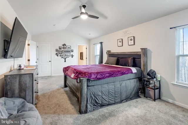 a bedroom with a bed dresser and a flat tv screen