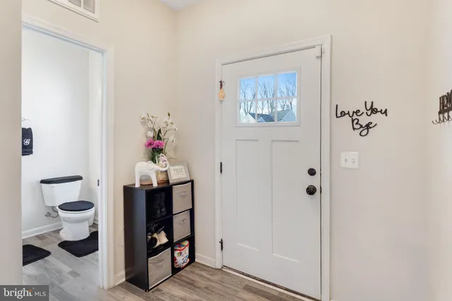 a view of a hallway with wooden floor and closet