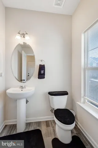 a bathroom with a toilet a sink and mirror