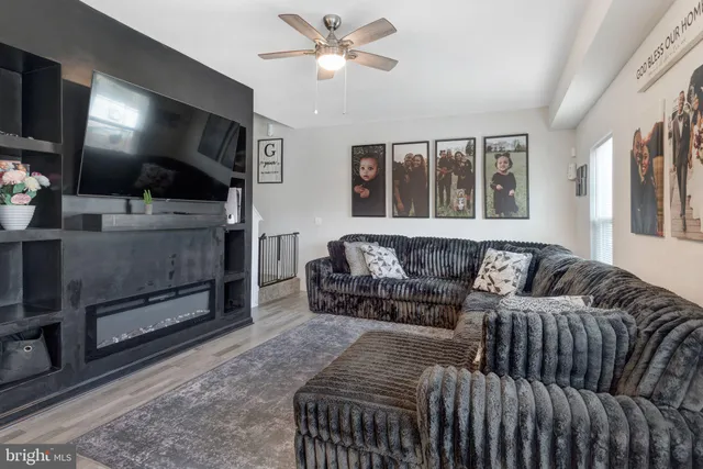a living room with furniture a flat screen tv and a fireplace