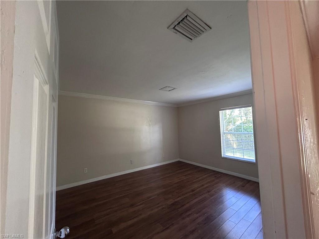 730 111th Avenue North Naples, FL 34108 - Photo 5 of 12 an empty room with wooden floor and windows