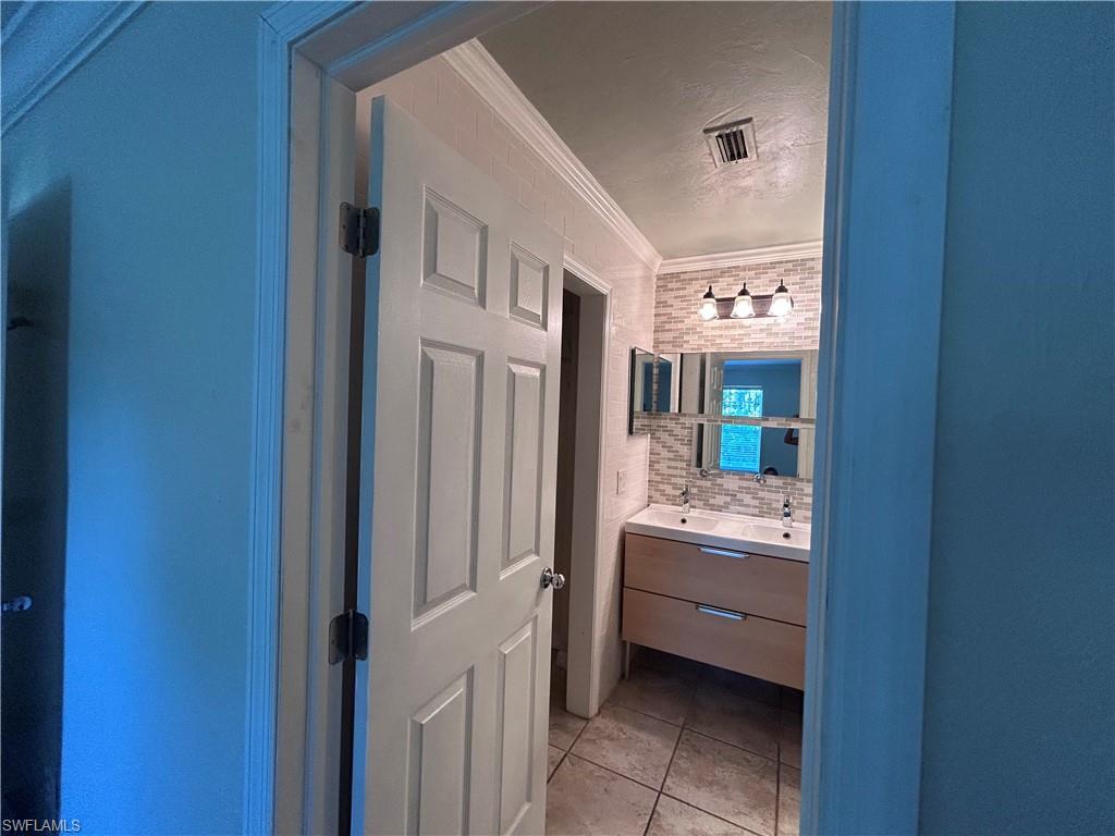 730 111th Avenue North Naples, FL 34108 - Photo 6 of 12 a bathroom with a double vanity sink and mirror