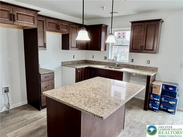 a kitchen with a sink a counter space and cabinets