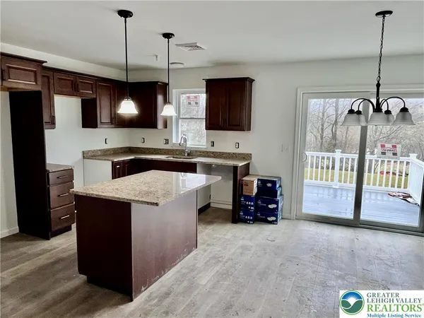 a kitchen with kitchen island a sink stove and refrigerator