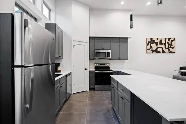 a kitchen with stainless steel appliances a refrigerator stove microwave and sink