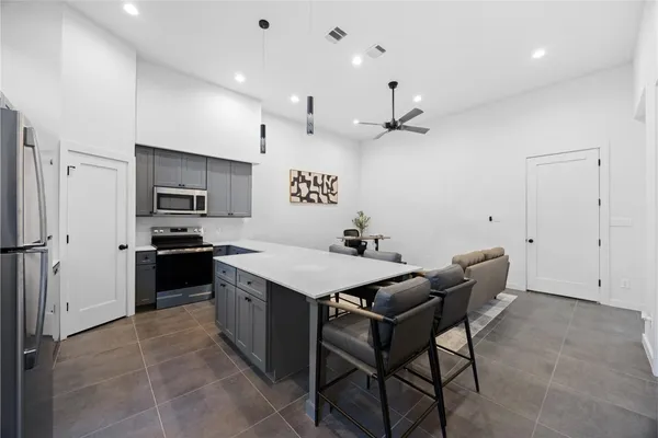 a kitchen with a table chairs microwave and cabinets