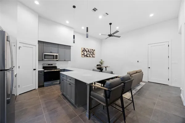 a kitchen with a table chairs refrigerator and microwave