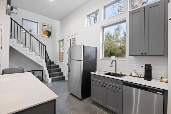 a kitchen with sink a refrigerator and cabinets