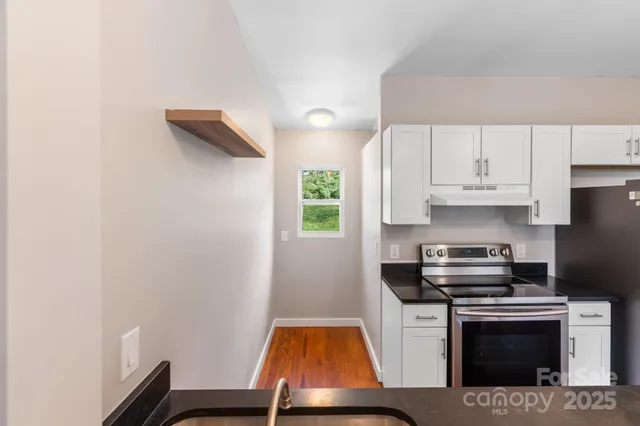 a kitchen with white cabinets and a stove