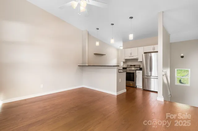 a view of kitchen with stainless steel appliances a refrigerator and wooden floor