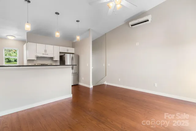 a view of kitchen with granite countertop cabinets and refrigerator