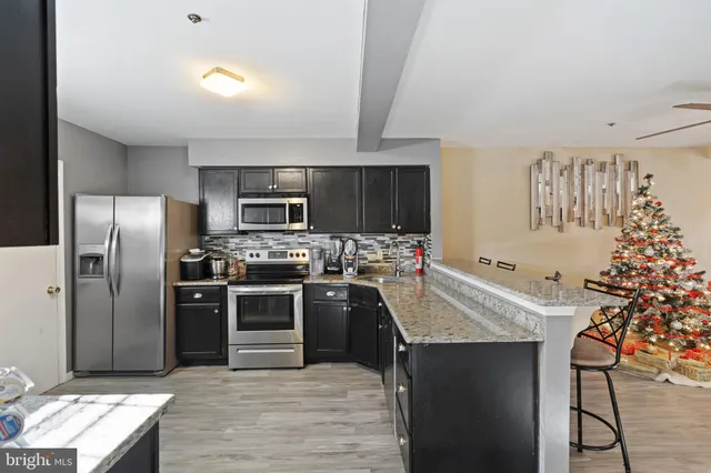 a kitchen with stainless steel appliances granite countertop a sink stove and refrigerator