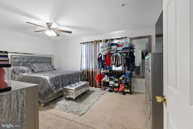 a bed room with a bed and a ceiling fan