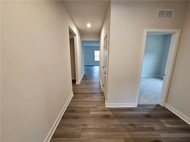 a view of a hallway with wooden floor and staircase
