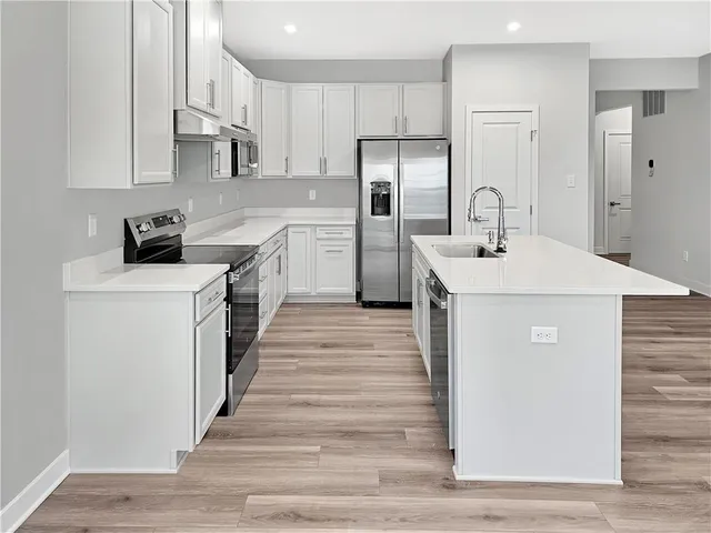 a kitchen with stainless steel appliances a white stove top oven and refrigerator