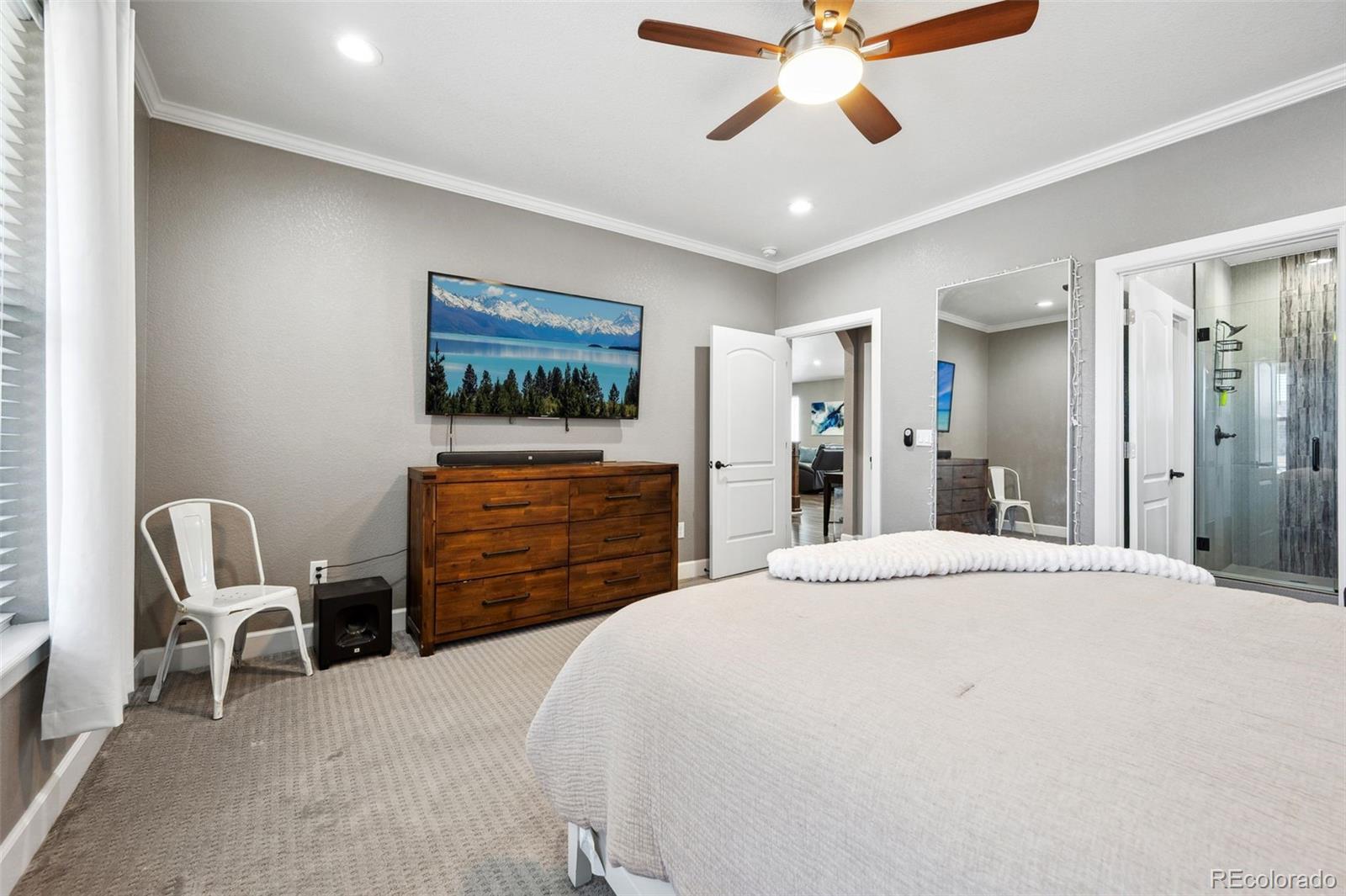 156 Chapel Hill Circle Brighton, CO 80601 - Photo 11 of 48 a bedroom with a bed and a chandelier