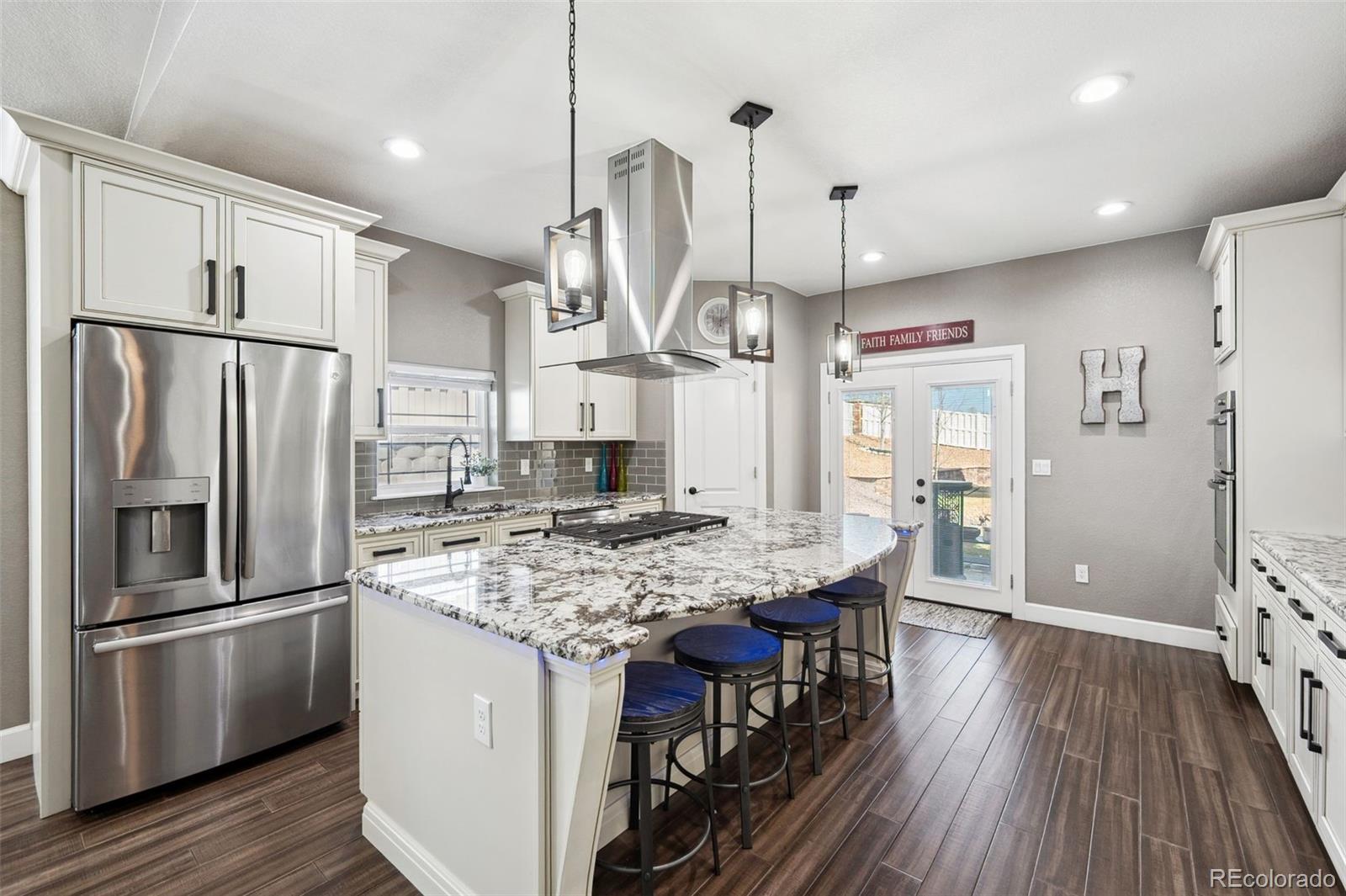 156 Chapel Hill Circle Brighton, CO 80601 - Photo 14 of 48 a kitchen with stainless steel appliances granite countertop a refrigerator a stove a sink dishwasher and a dining table with wooden floor
