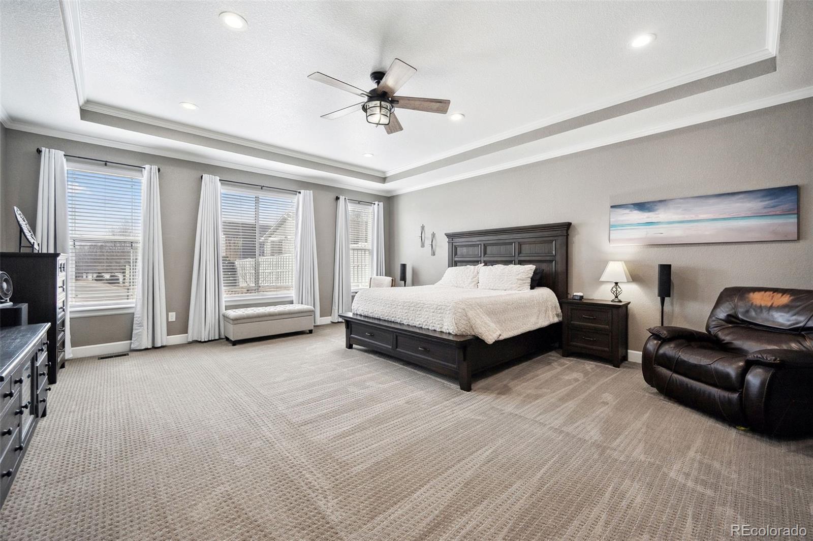 156 Chapel Hill Circle Brighton, CO 80601 - Photo 25 of 48 a spacious bedroom with a bed a couch and a chandelier