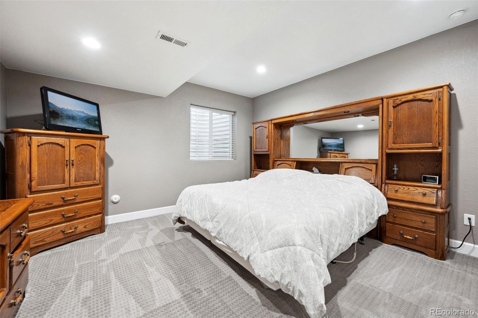 156 Chapel Hill Circle Brighton, CO 80601 - Photo 38 of 48 a bedroom with a bed and dresser