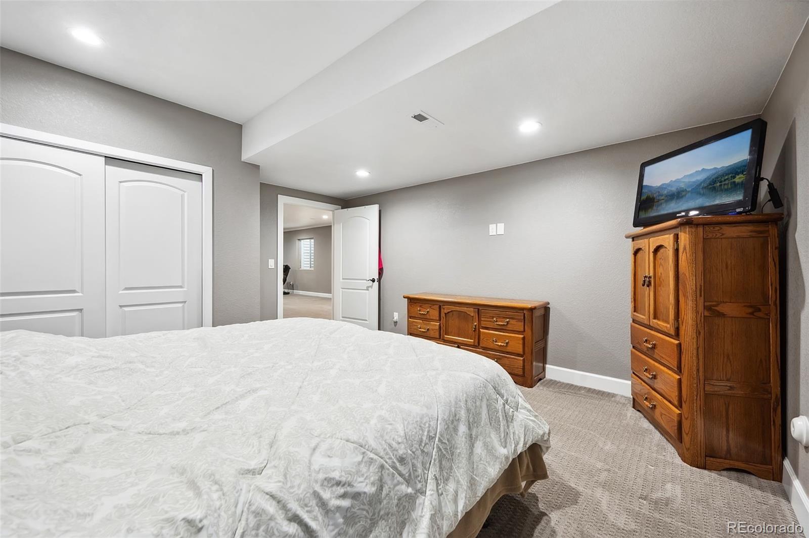 156 Chapel Hill Circle Brighton, CO 80601 - Photo 39 of 48 a bedroom with a bed and wooden floor