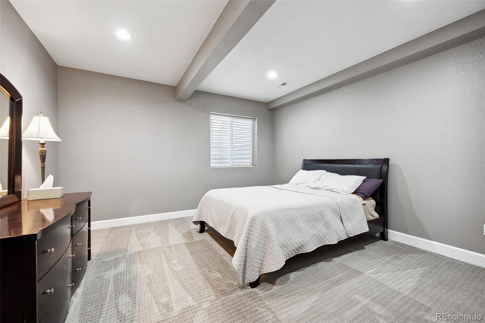 156 Chapel Hill Circle Brighton, CO 80601 - Photo 40 of 48 a bedroom with a large bed and a flat tv screen on dresser