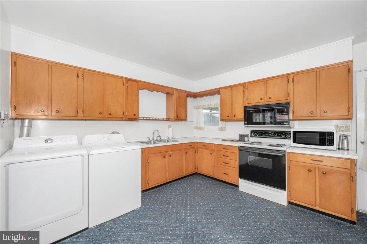 207 Barbara Street Frederick, MD 21701 - Photo 8 of 46 a kitchen with stainless steel appliances granite countertop a stove top oven a sink dishwasher and a refrigerator with wooden cabinets