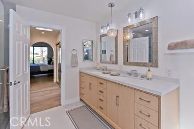 a en suite bathroom with a granite countertop sink mirror and double