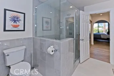 a bathroom with a toilet a sink and glass door