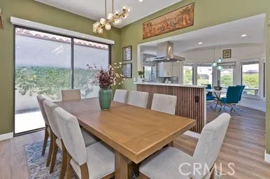a view of a dining room with furniture a chandelier and wooden floor