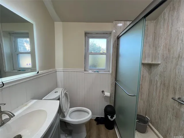 a bathroom with a toilet a sink and mirror