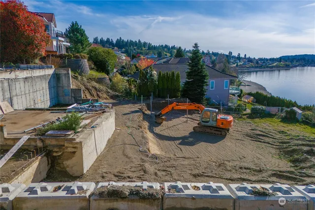 a view of a backyard with table and chairs potted plants and water view