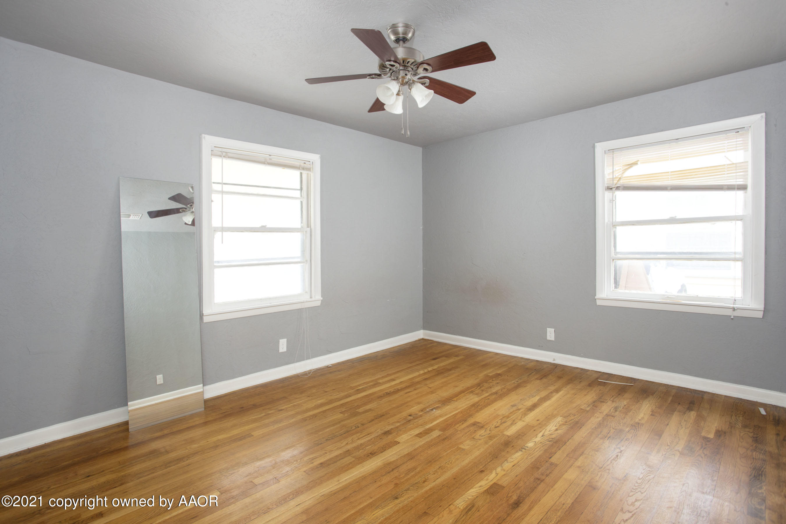 4312 South Monroe Street Amarillo, TX 79110 - Photo 8 of 18 a view of empty room with wooden floor and fan
