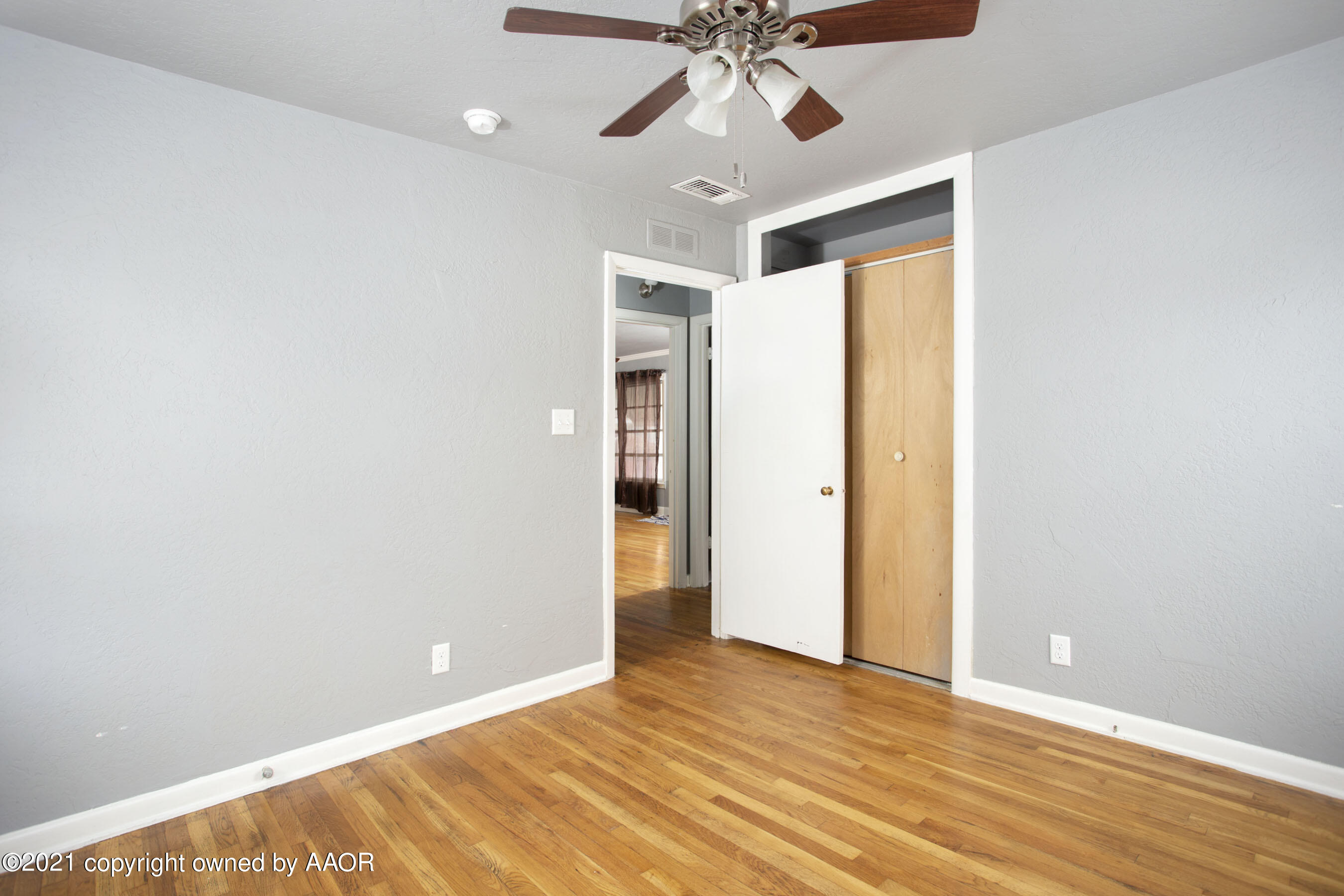 4312 South Monroe Street Amarillo, TX 79110 - Photo 10 of 18 a view of an empty room with window and wooden floor