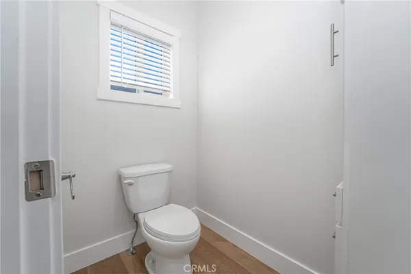a white toilet sitting in a bathroom next to a window
