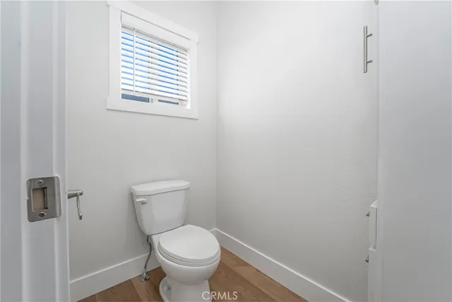 a white toilet sitting in a bathroom next to a window