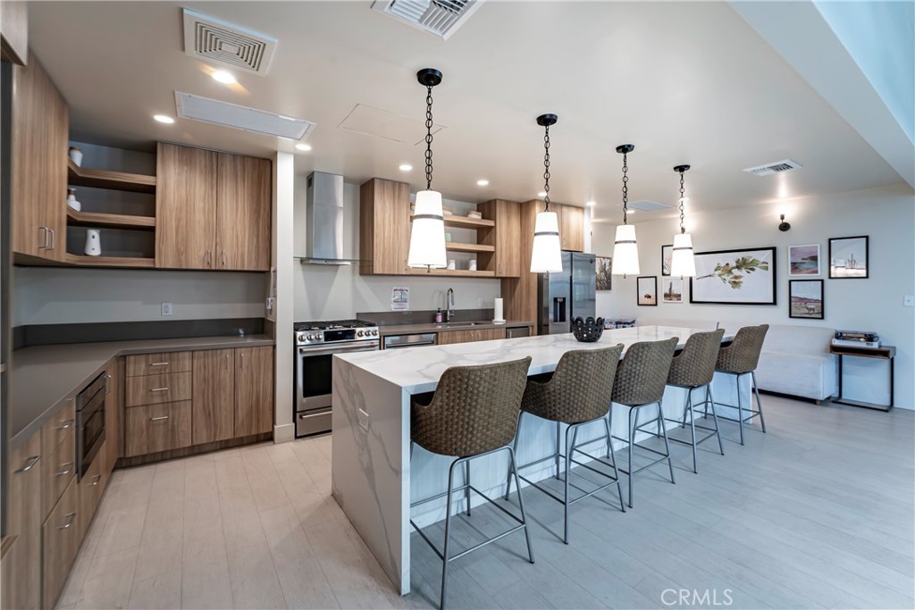 1120 East Mission Road, Unit 57 Fallbrook, CA 92028 - Photo 22 of 25 a kitchen with stainless steel appliances granite countertop a stove top oven a sink dishwasher a dining table and chairs with wooden floor