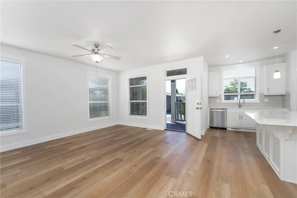 a view of a kitchen with a sink dishwasher cabinets and wooden floor