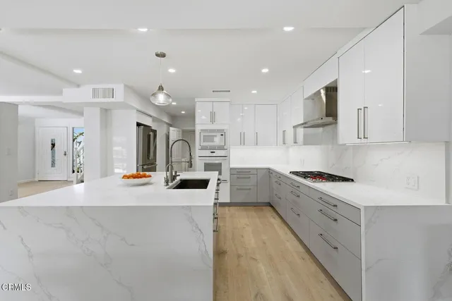 a large kitchen with stainless steel appliances lots of counter space and window