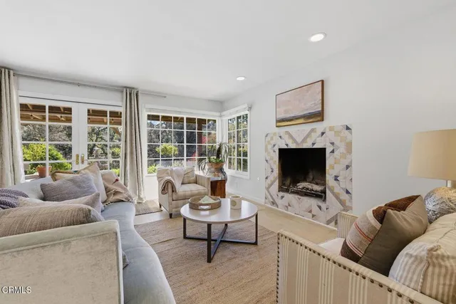 a living room with furniture a flat screen tv and a fireplace