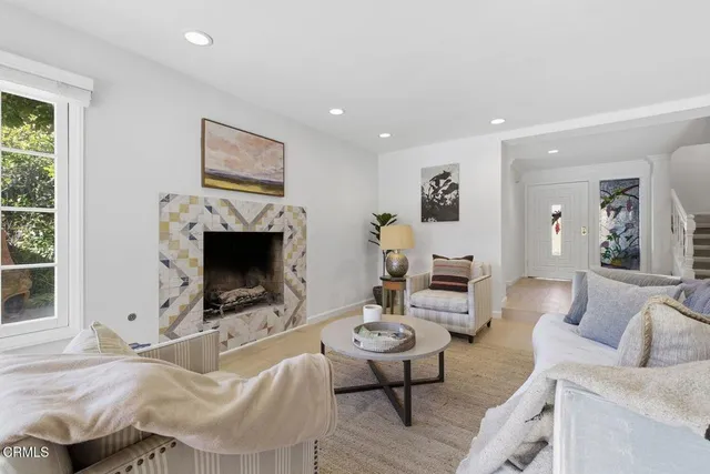 a living room with furniture a flat screen tv and a fireplace