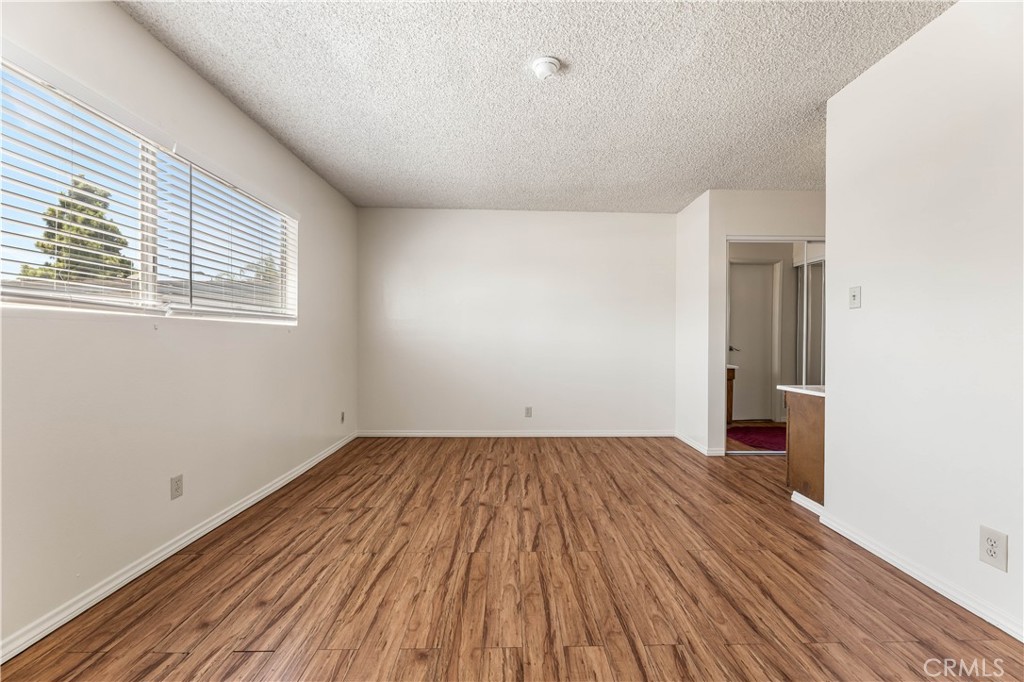 5530 Ackerfield Avenue, Unit 206 Long Beach, CA 90805 - Photo 14 of 33 an empty room with wooden floor and windows