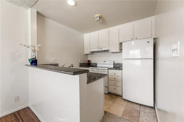 a kitchen with white cabinets and white appliances