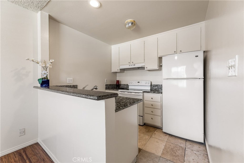 5530 Ackerfield Avenue, Unit 206 Long Beach, CA 90805 - Photo 8 of 33 a kitchen with white cabinets and white appliances