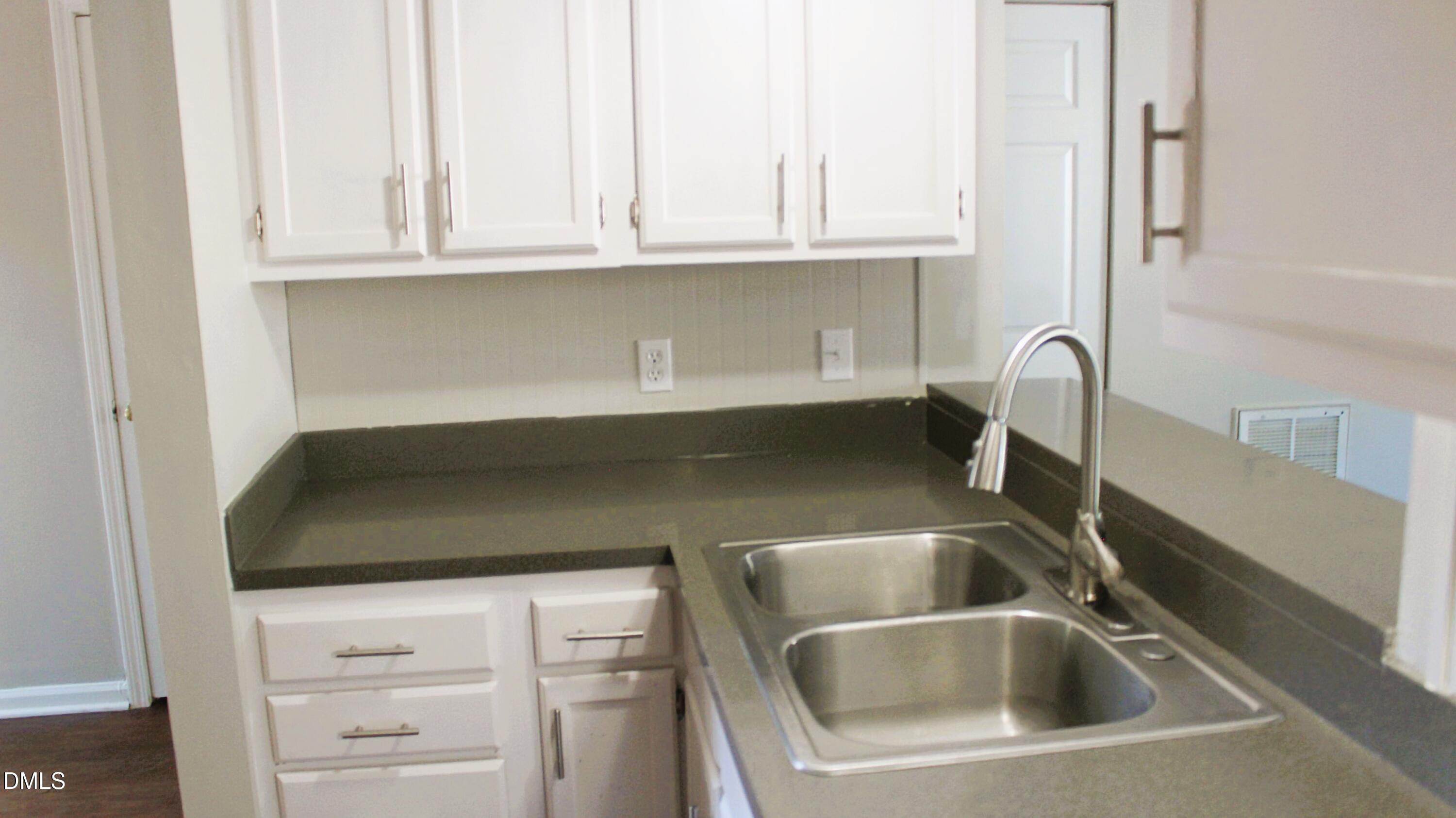 2706 Big Oak Street Raleigh, NC 27610 - Photo 8 of 11 a kitchen with granite countertop white cabinets and a sink