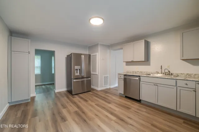 a kitchen with granite countertop a refrigerator and a sink