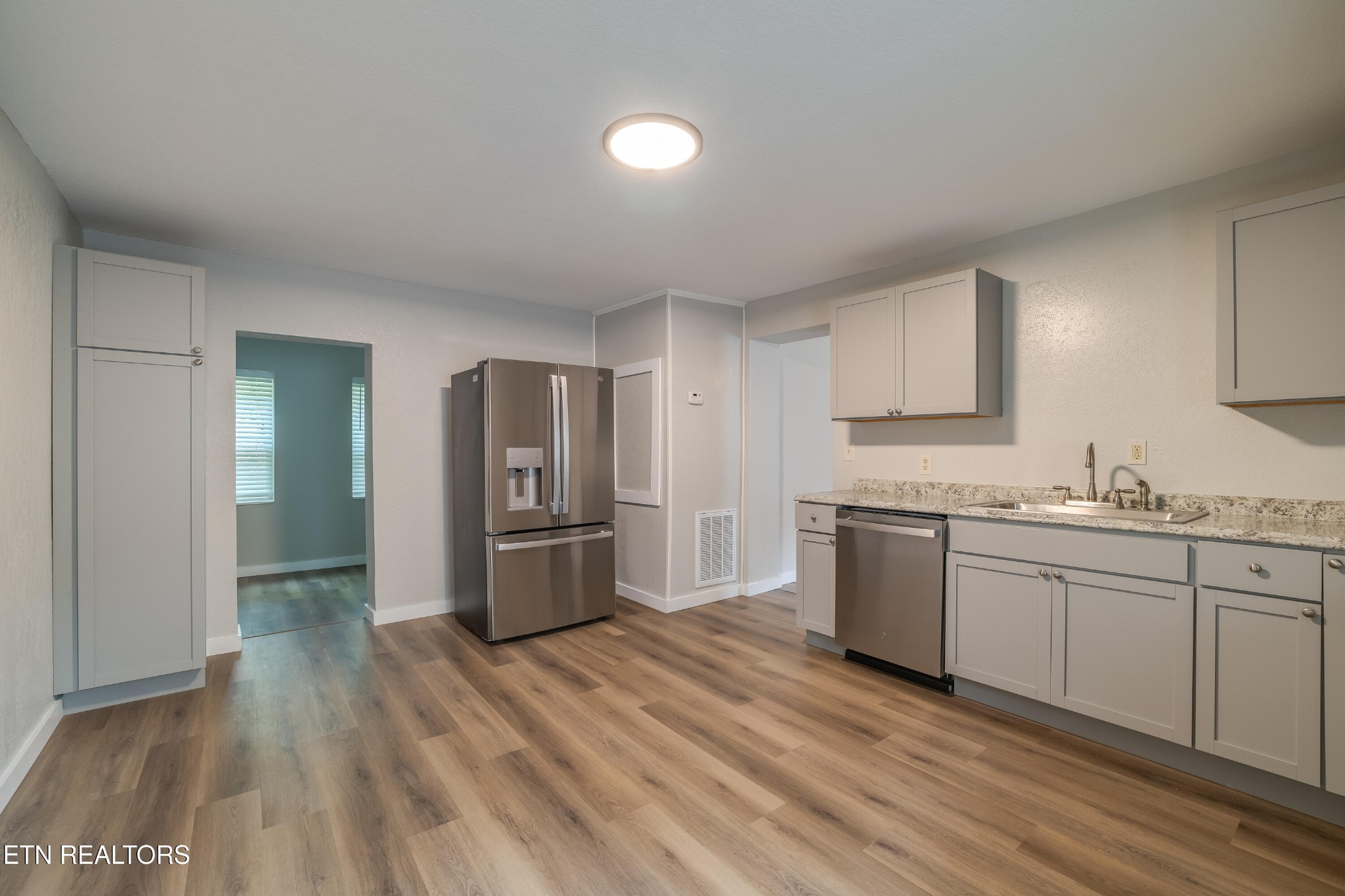 a kitchen with granite countertop a refrigerator and a sink